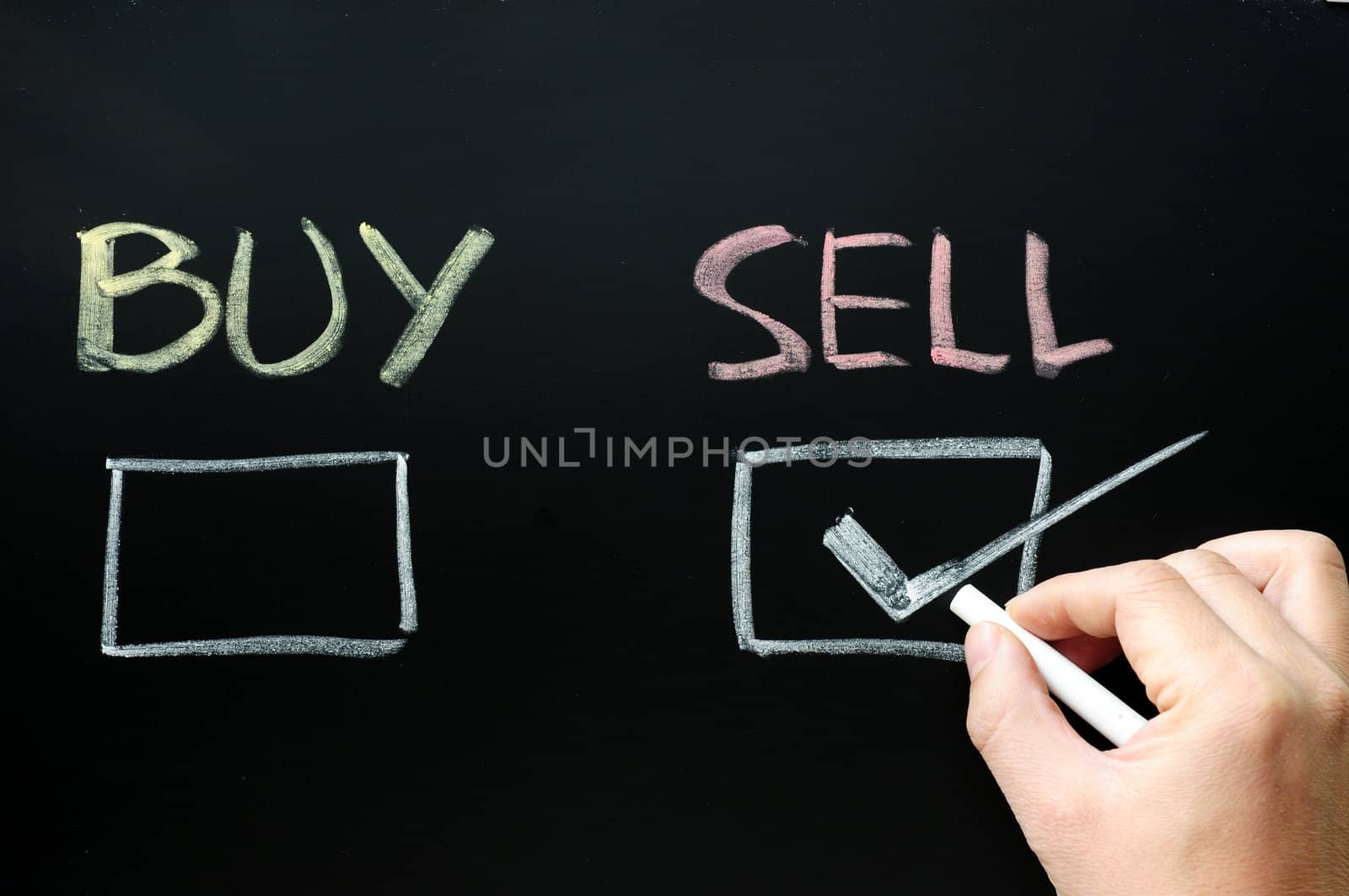Buy or sell check boxes on a blackboard. Finance, economy, stock or real estate concept - time to buy or sell.