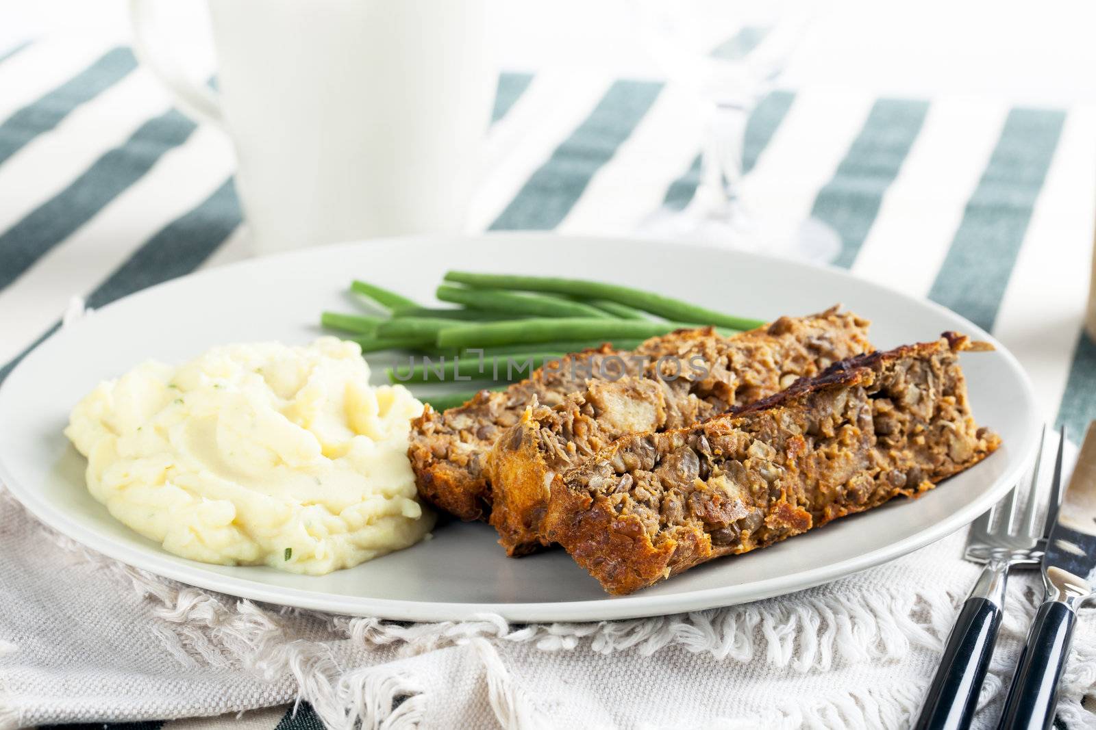 Vegetarian meal with lentil loaf, mashed potatoes and green beans.