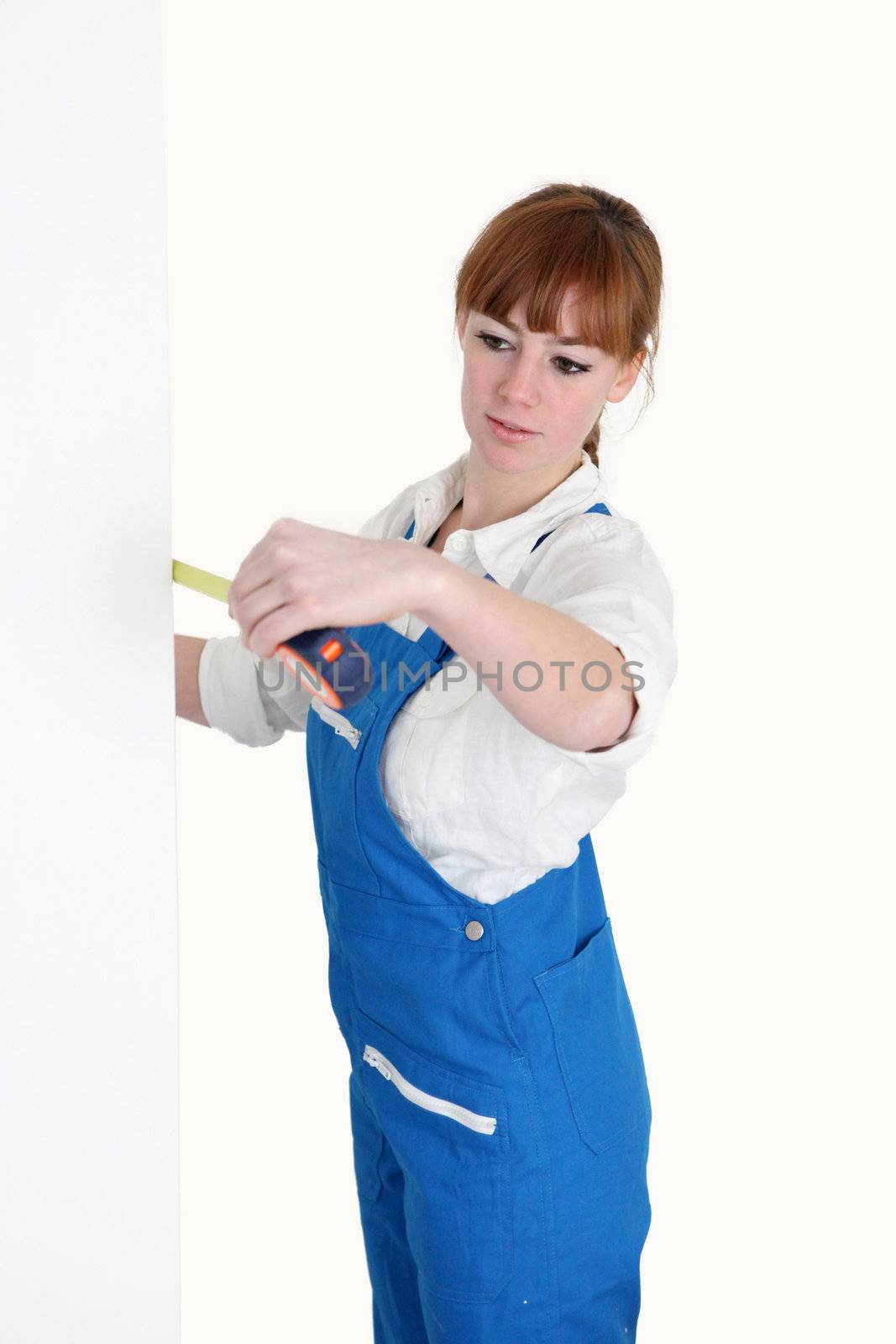 Female worker with a tape measure by phovoir