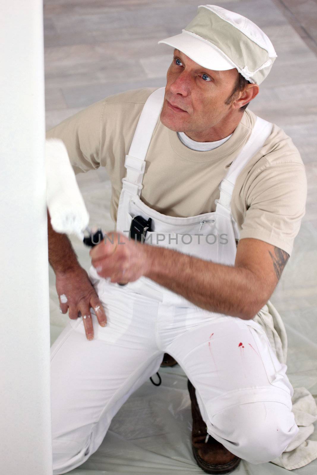 Tradesman painting a wall by phovoir