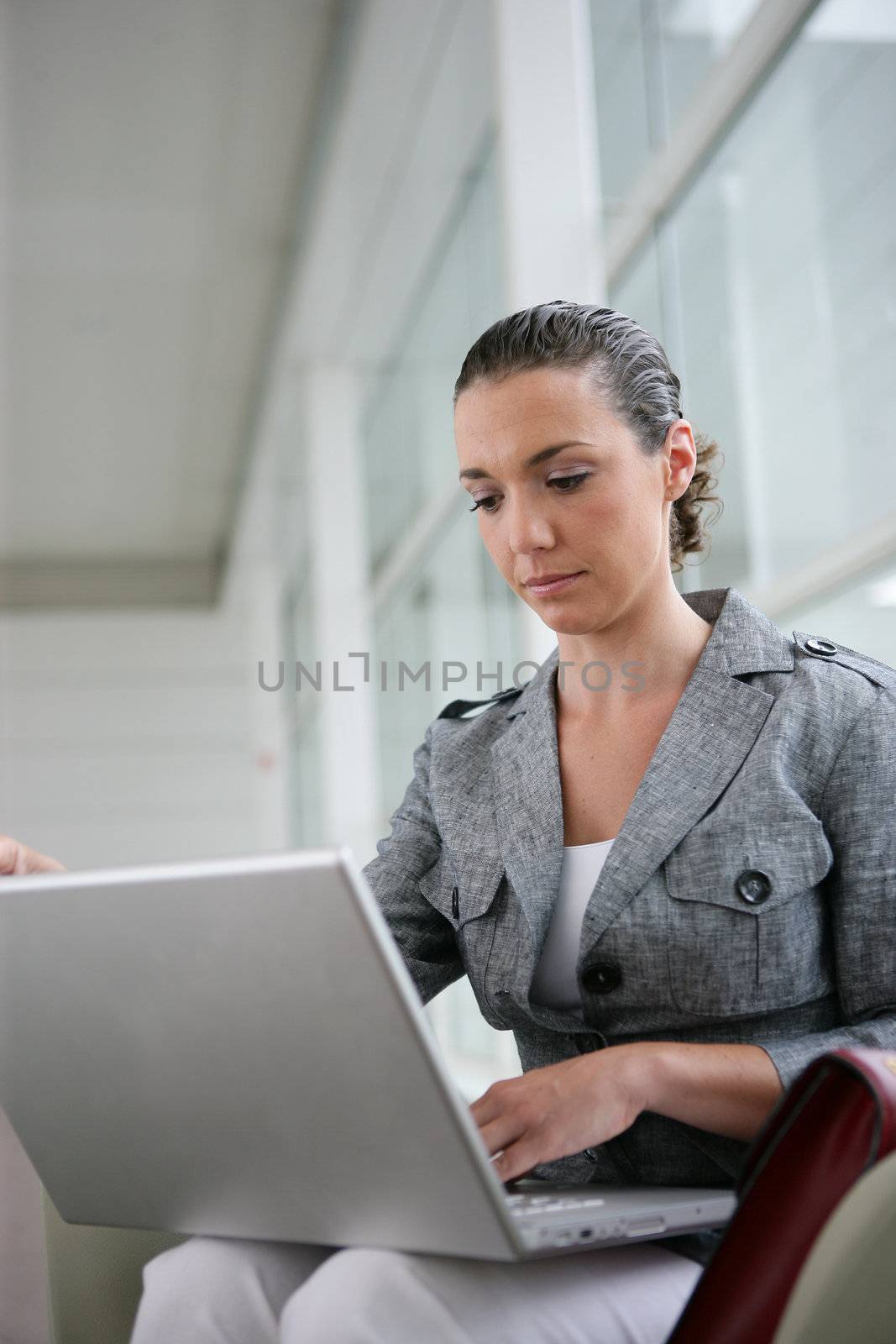 Woman working on her laptop by phovoir