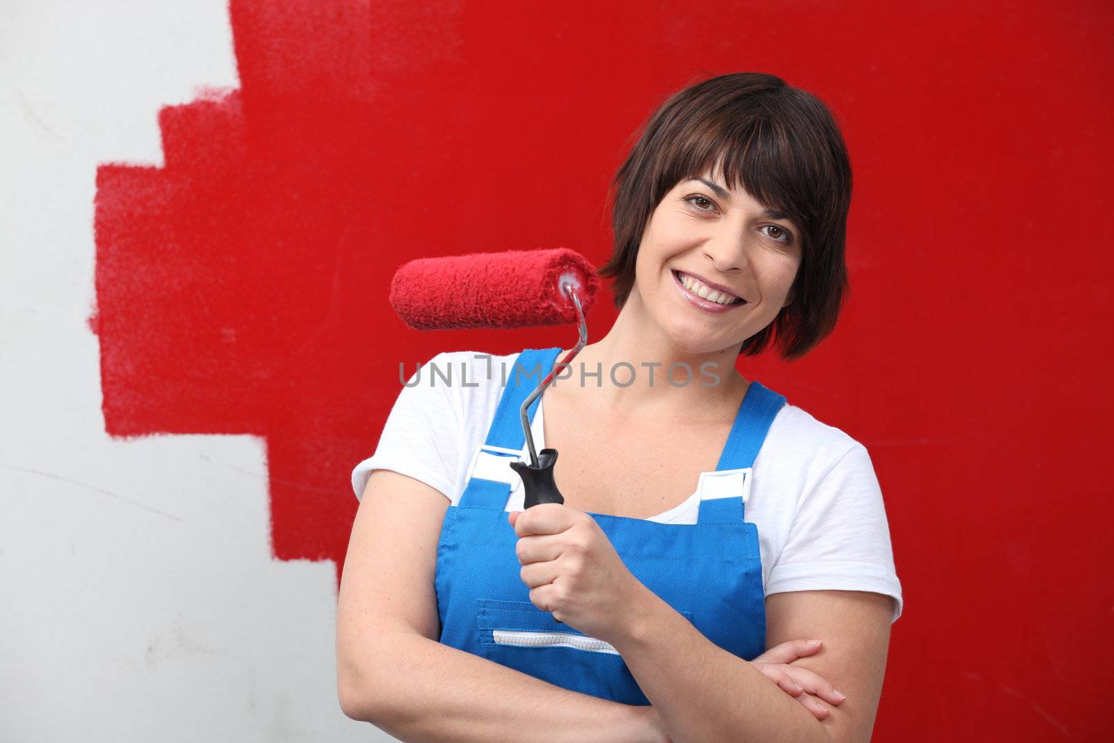 Woman painting wall in red by phovoir