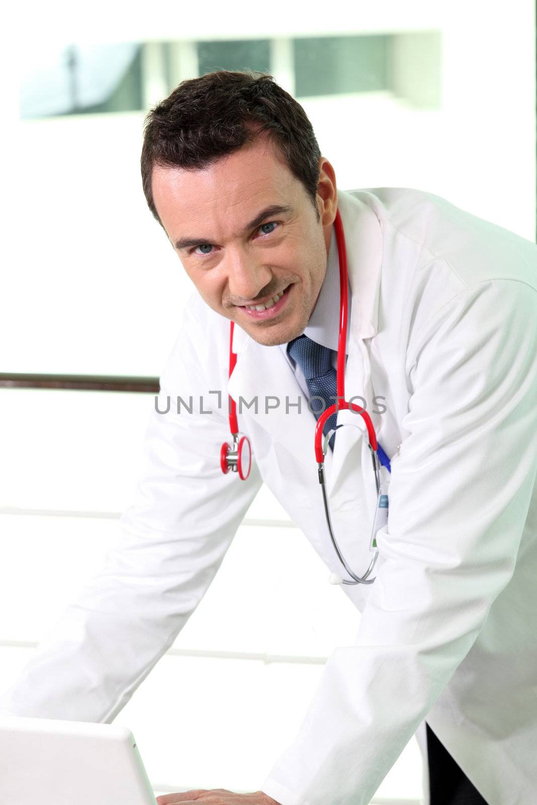 Male doctor in office by phovoir