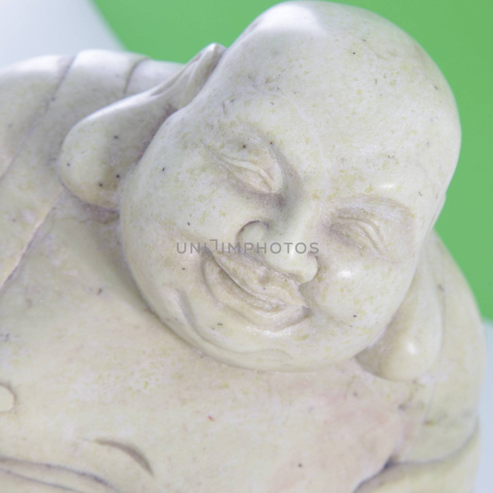 Closeup of the face of a white smiling Buddha statue