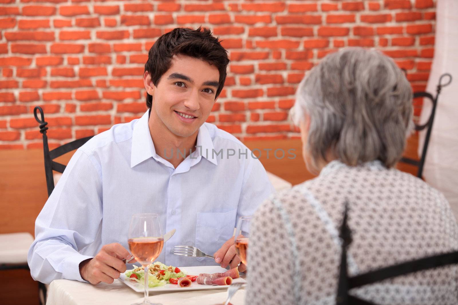 young man having lunch with his grandmother