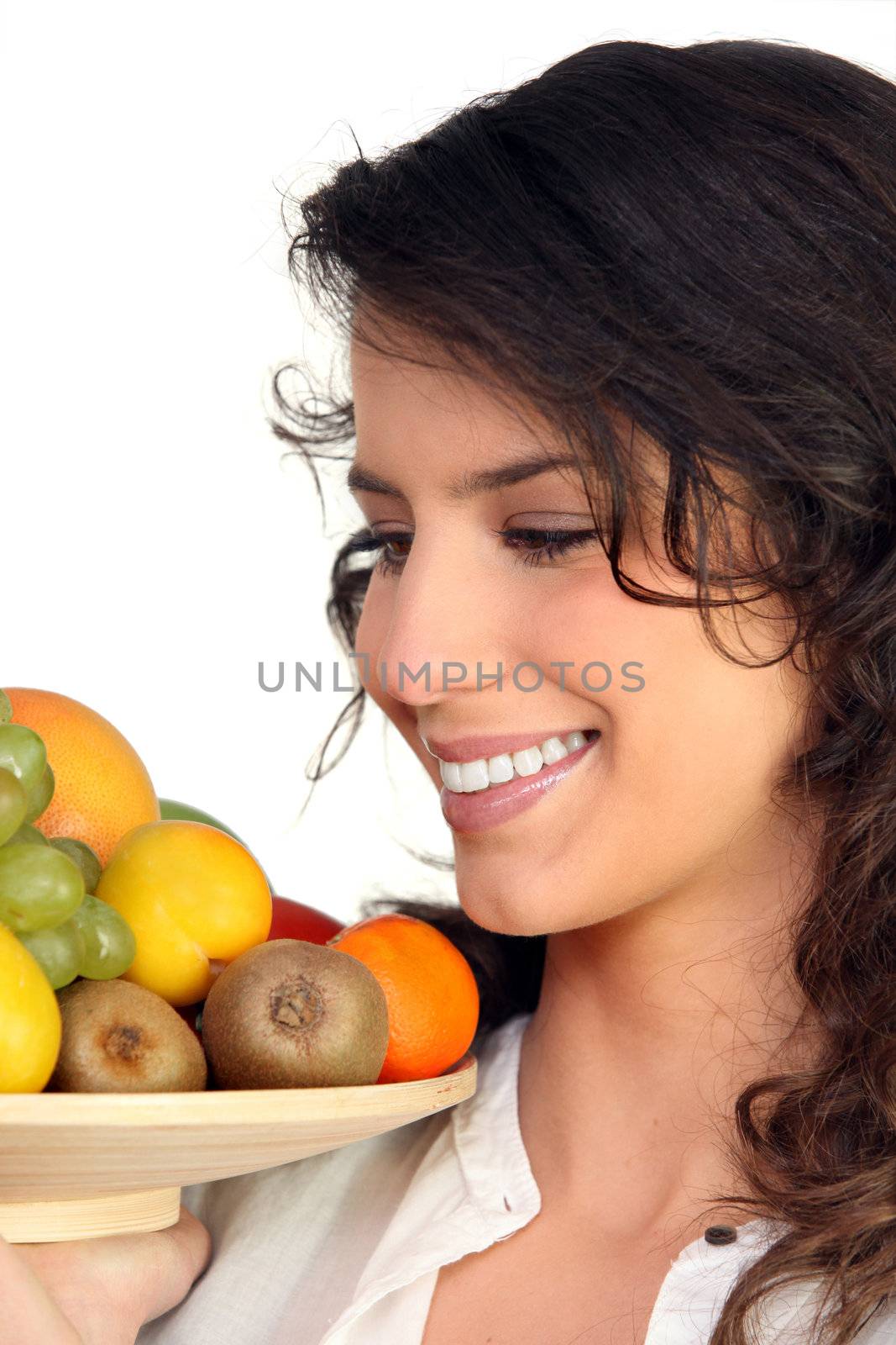 Woman carrying tray of fruits by phovoir