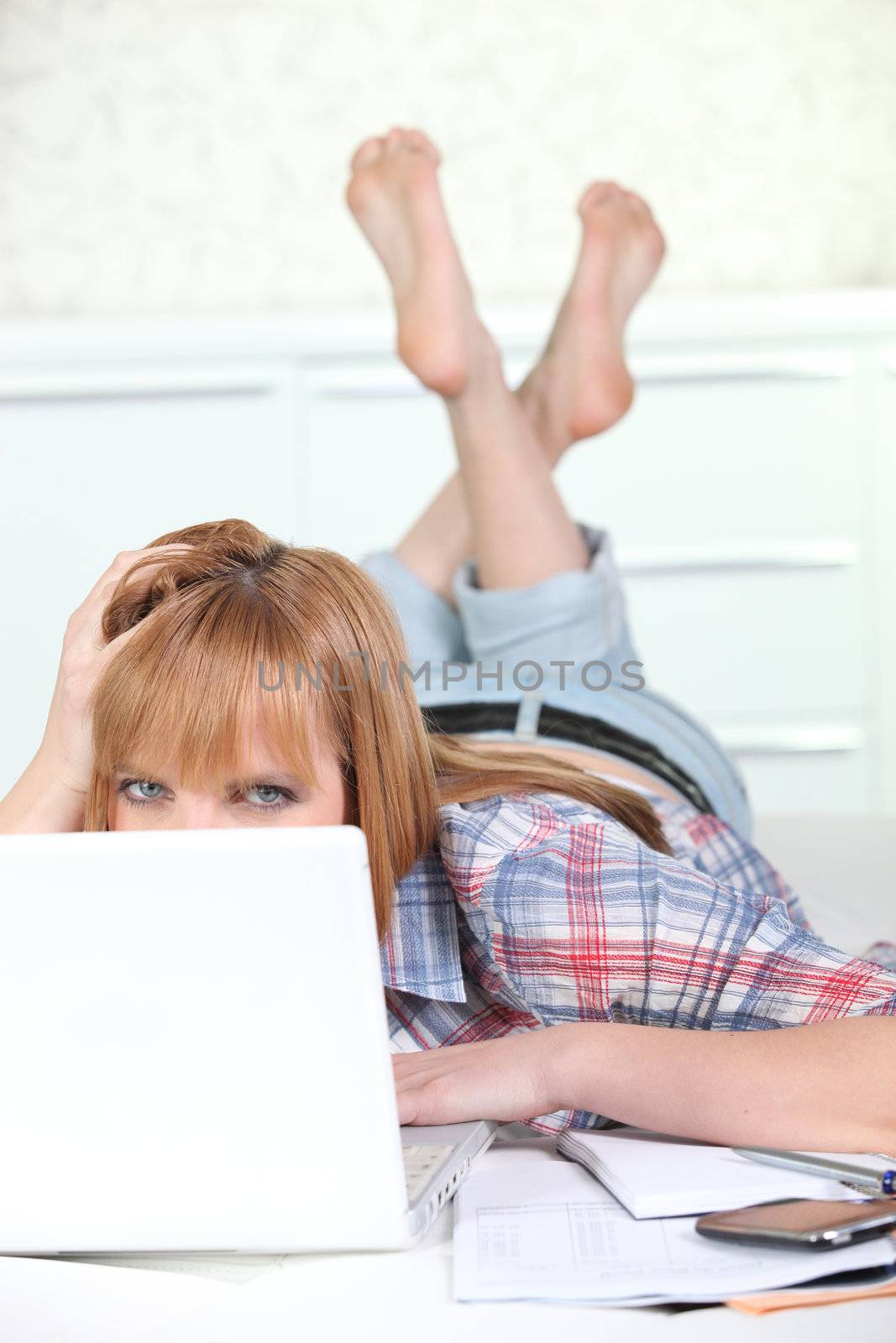 Young woman laid in front of computer by phovoir