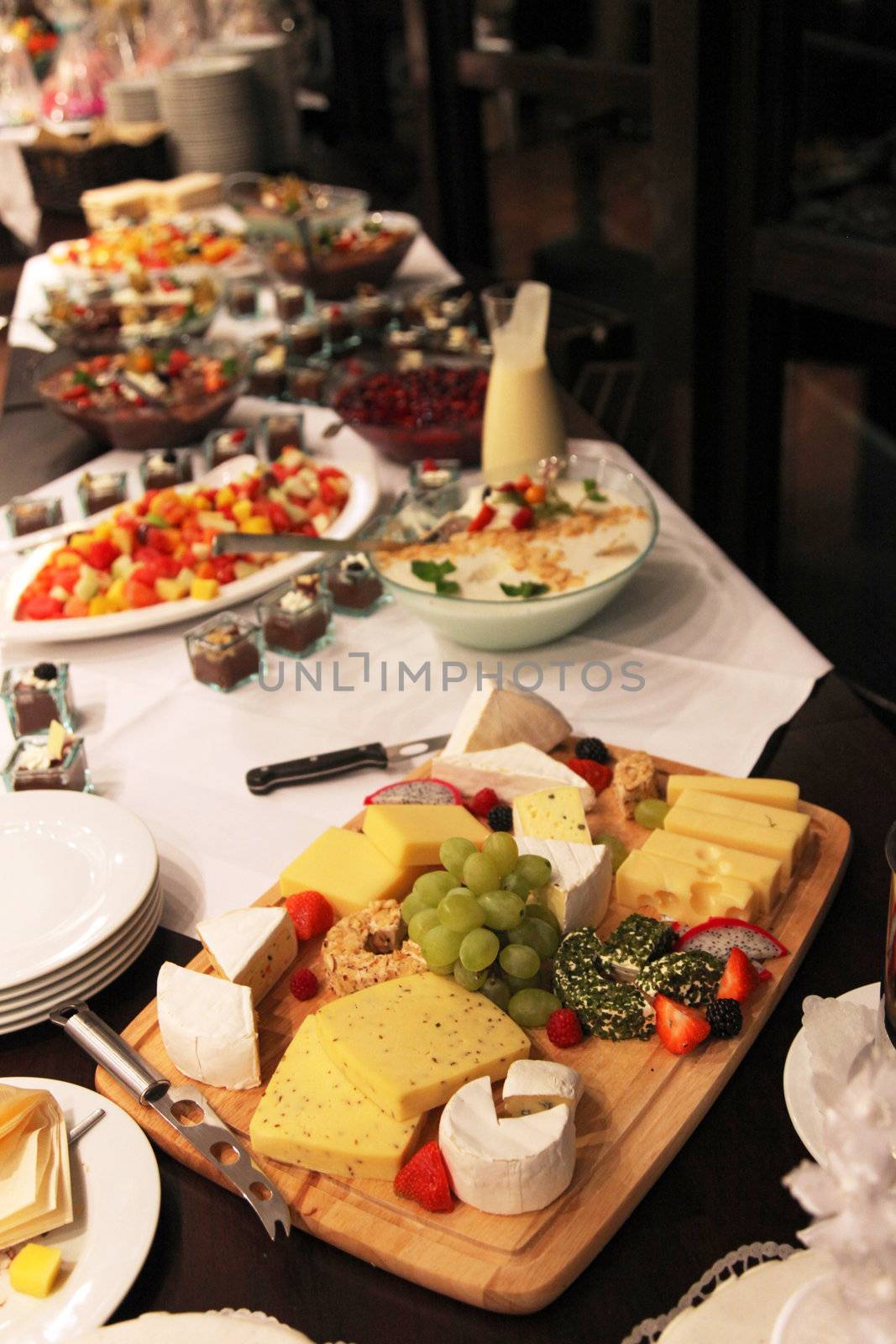 Cheese platter with an assortment of gourmet cheeses displayed on a buffet table at a catered event or function in a restaurant or venue