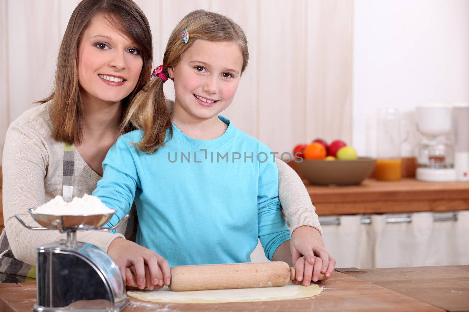 mother and daughter cooking together by phovoir