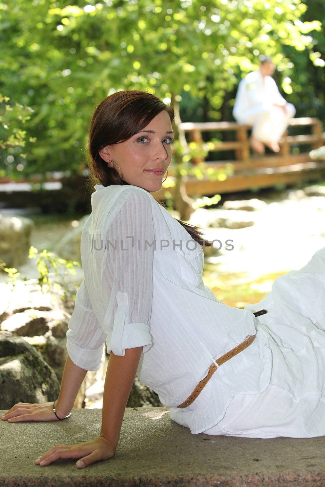 Woman sat in relaxing garden by phovoir