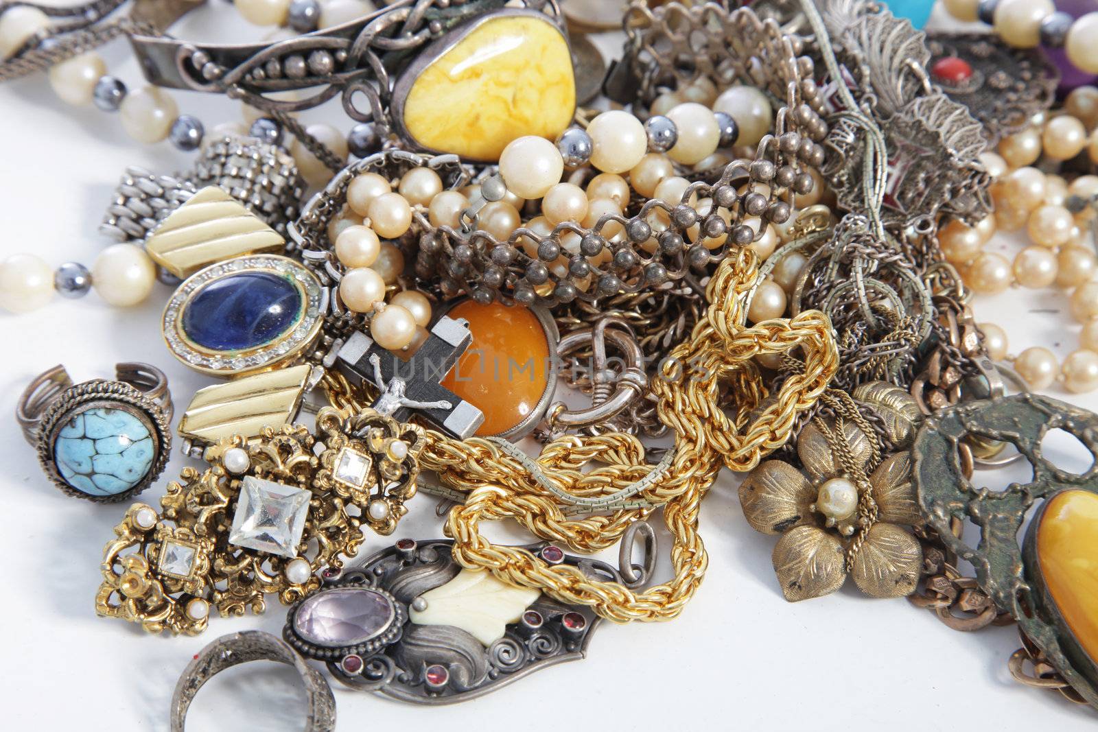 Collection of assorted gemstone jewellery with pearls, necklaces, rings, bracelets and chains in a jumbled pile for a fashion background