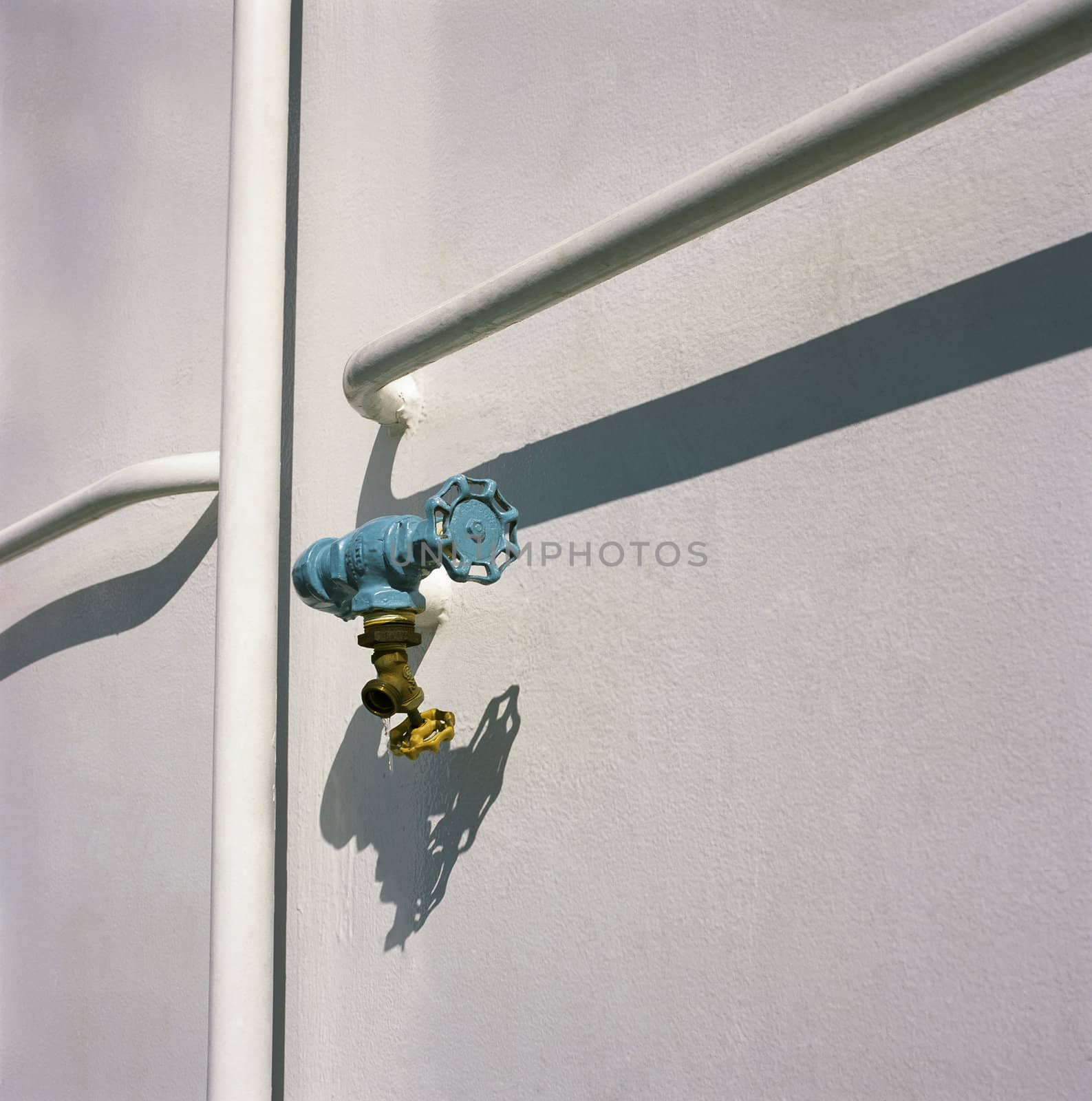 Blue water tap and white wall