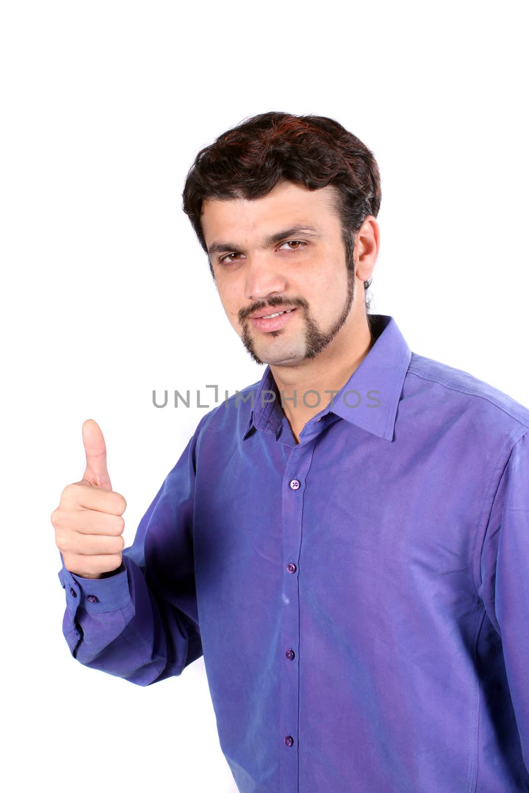 A young Indian guy wishing the best with a thumbs up sign, on white studio background.