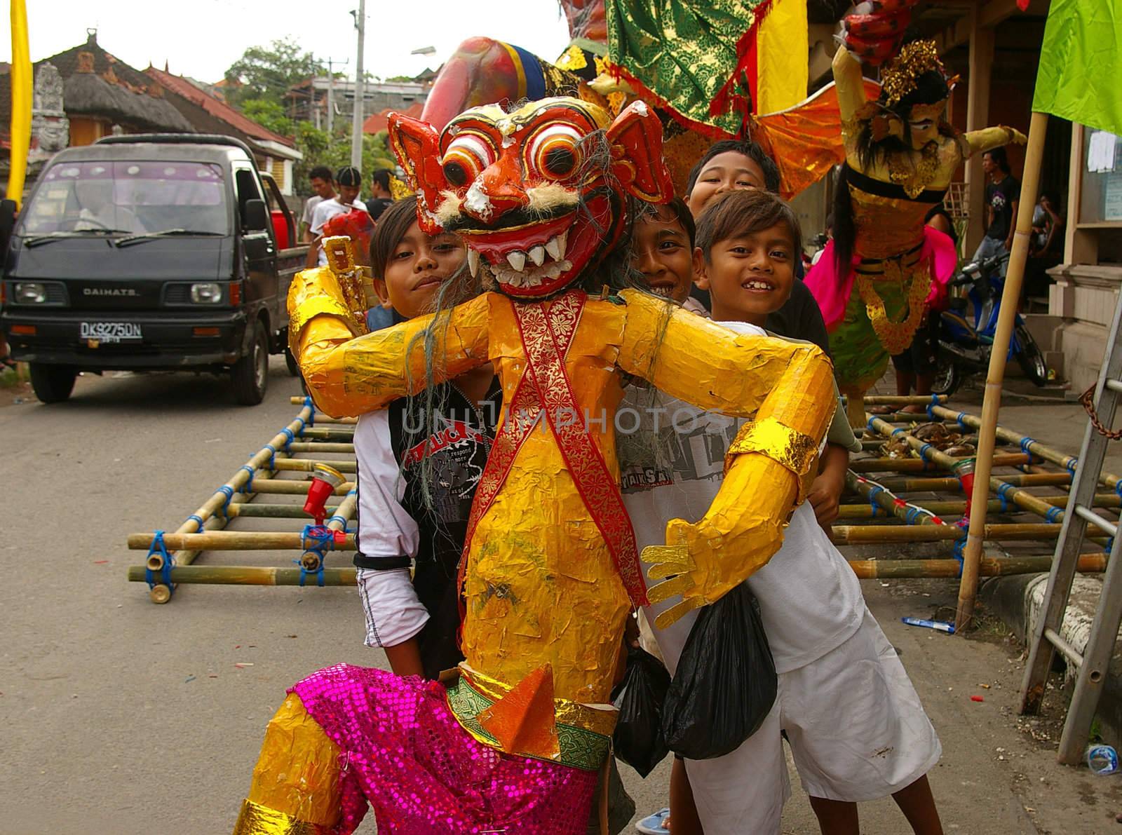 Boys with a monster statue for the Balinese Hindu festival of Pengrupukan. This celebrates the Balinese New Year and the arrival of spring. Nusa Dua, Bali, Indonesia