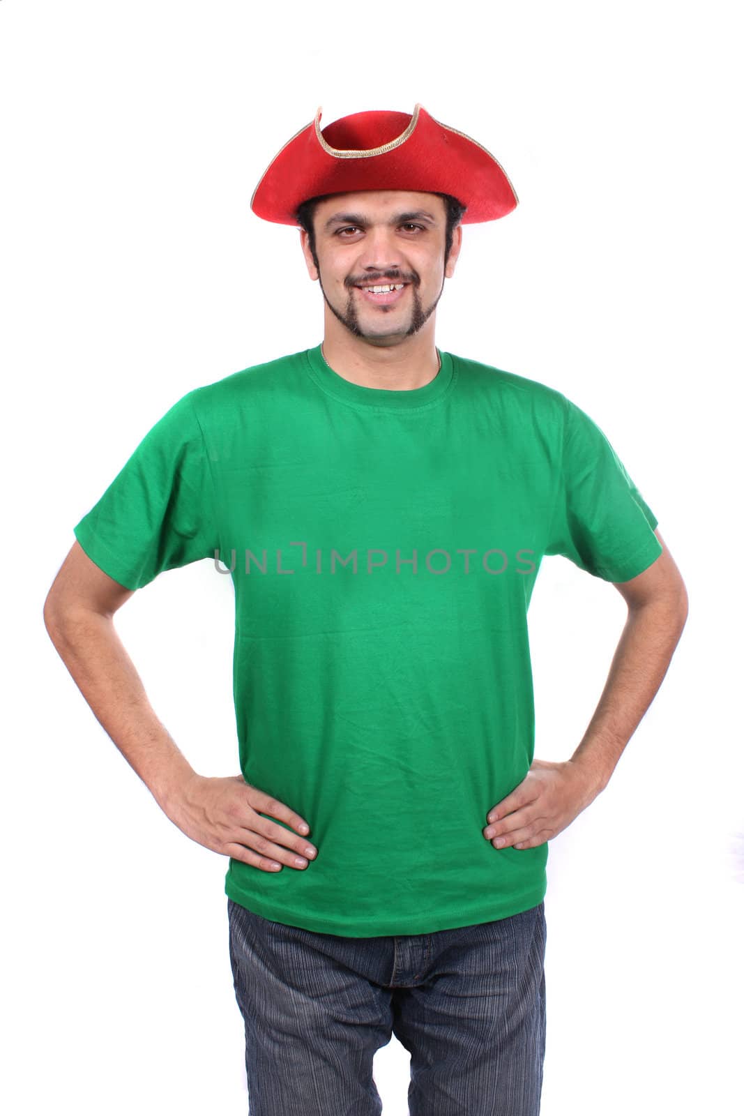 A young Indian guy wearing a red ship captain hat, on white studio background.
