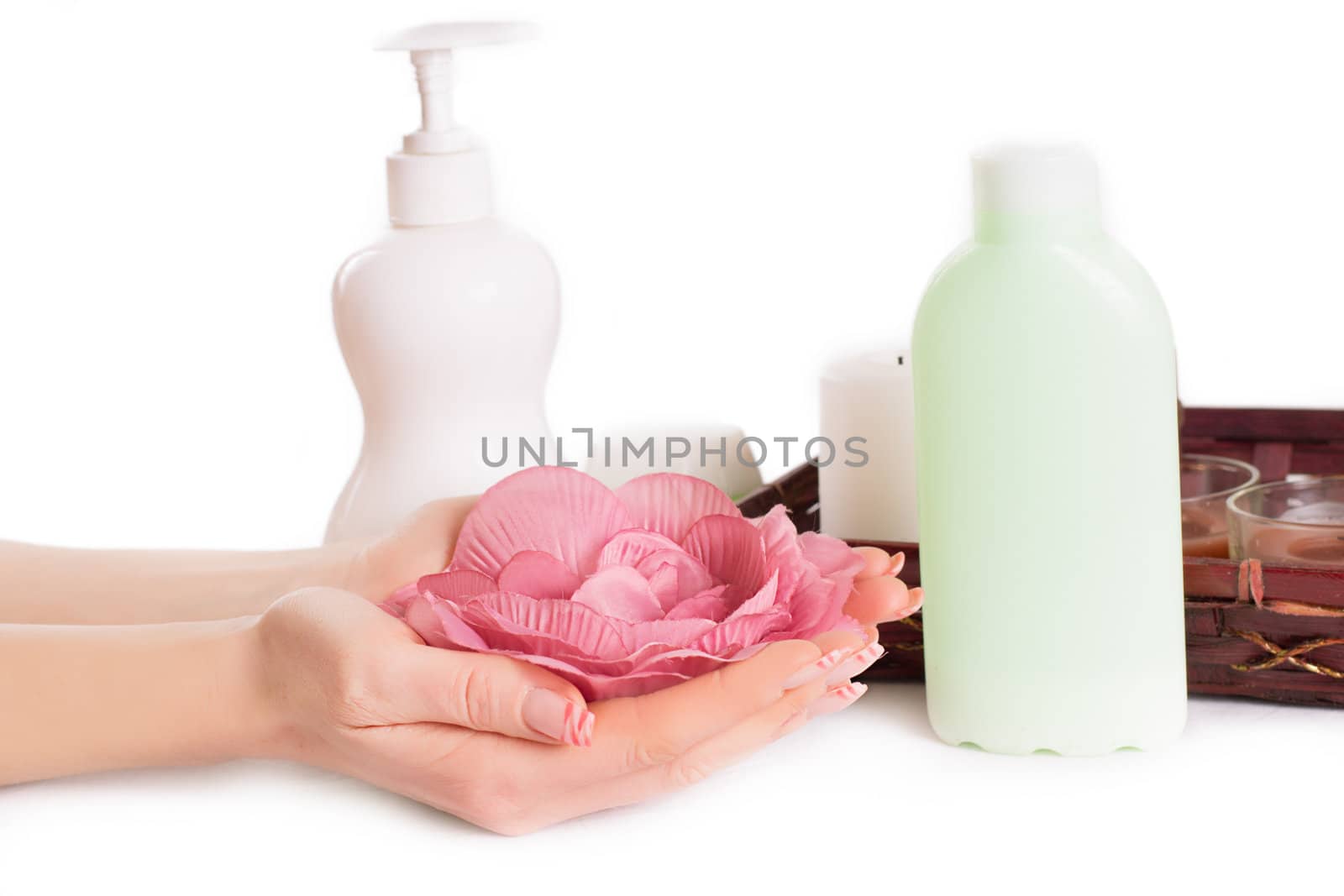 Woman hands with manicure and hand care products on white