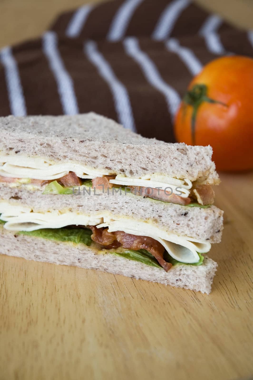 close up bacon and chicken sandwich on wooden table with tomato background