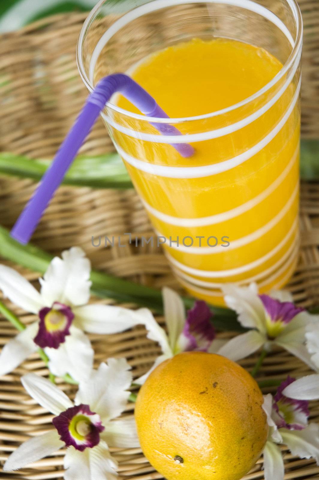 close up glass of fresh orange juice with drinking straw
