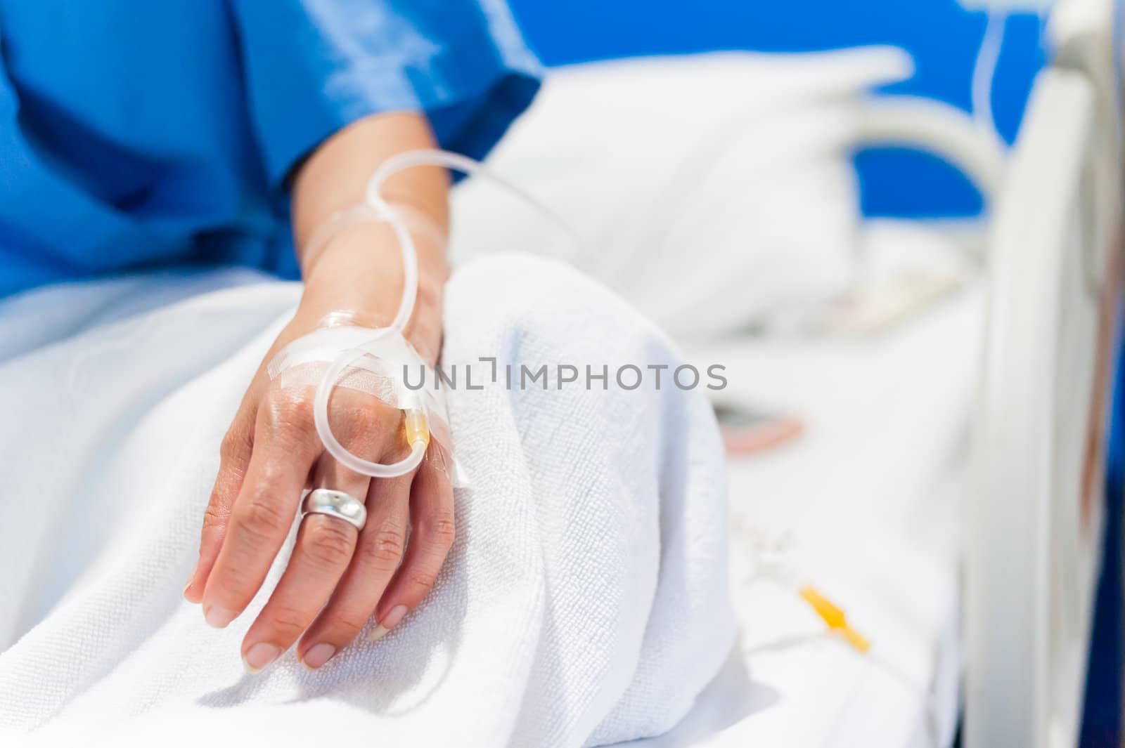 close up of iv drip in woman hand on bed in hospital