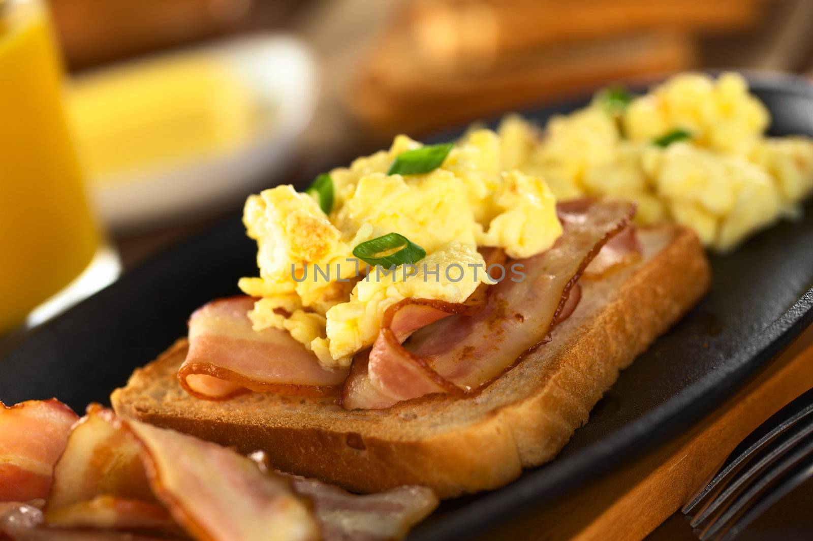 Fried bacon and scrambled egg on toast bread (Selective Focus, Focus on the front of the shallot in the front) 