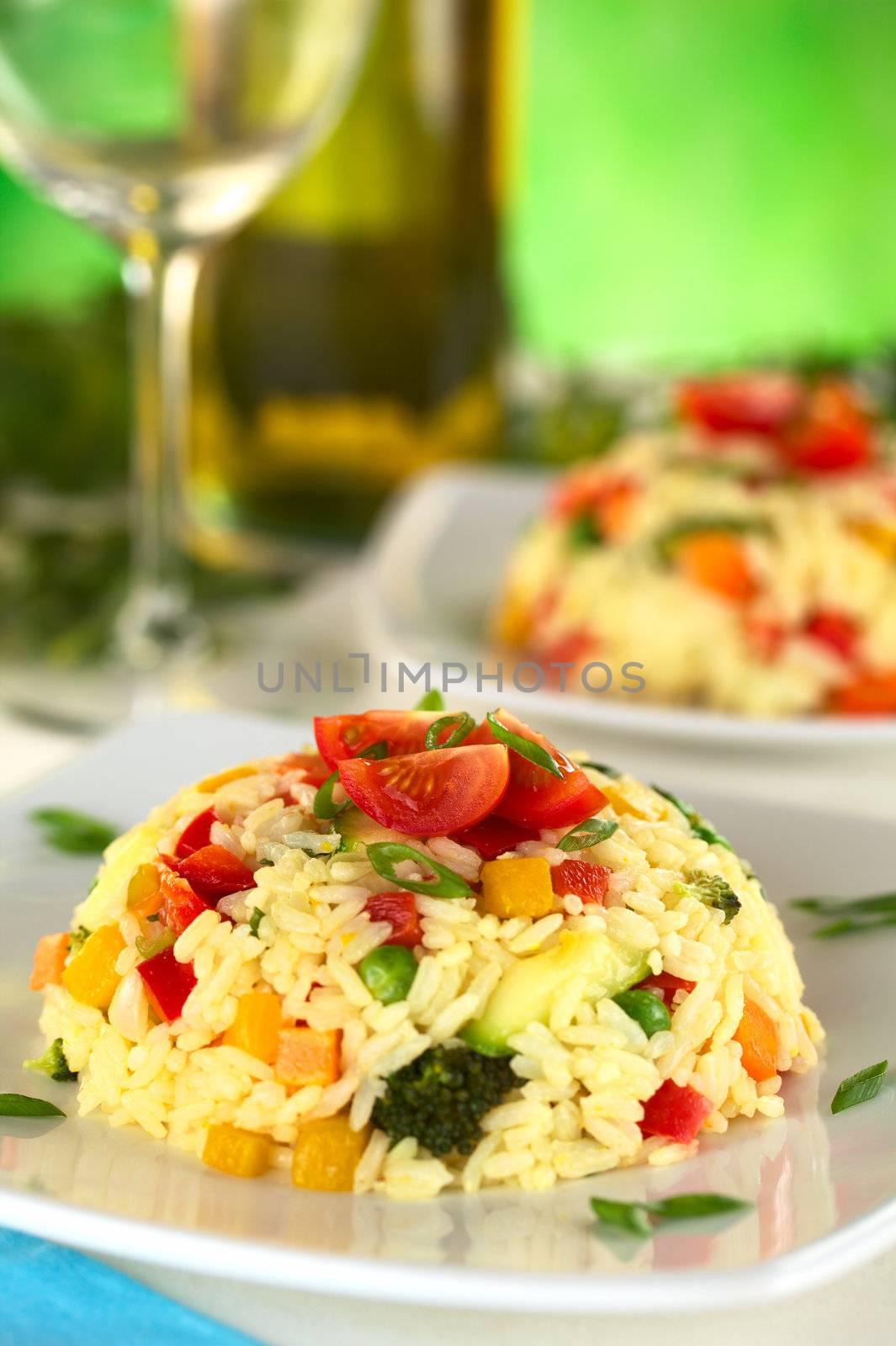 Vegetable risotto garnished with cherry tomato and shallot (Selective Focus, Focus on the front of the cherry tomato on top)