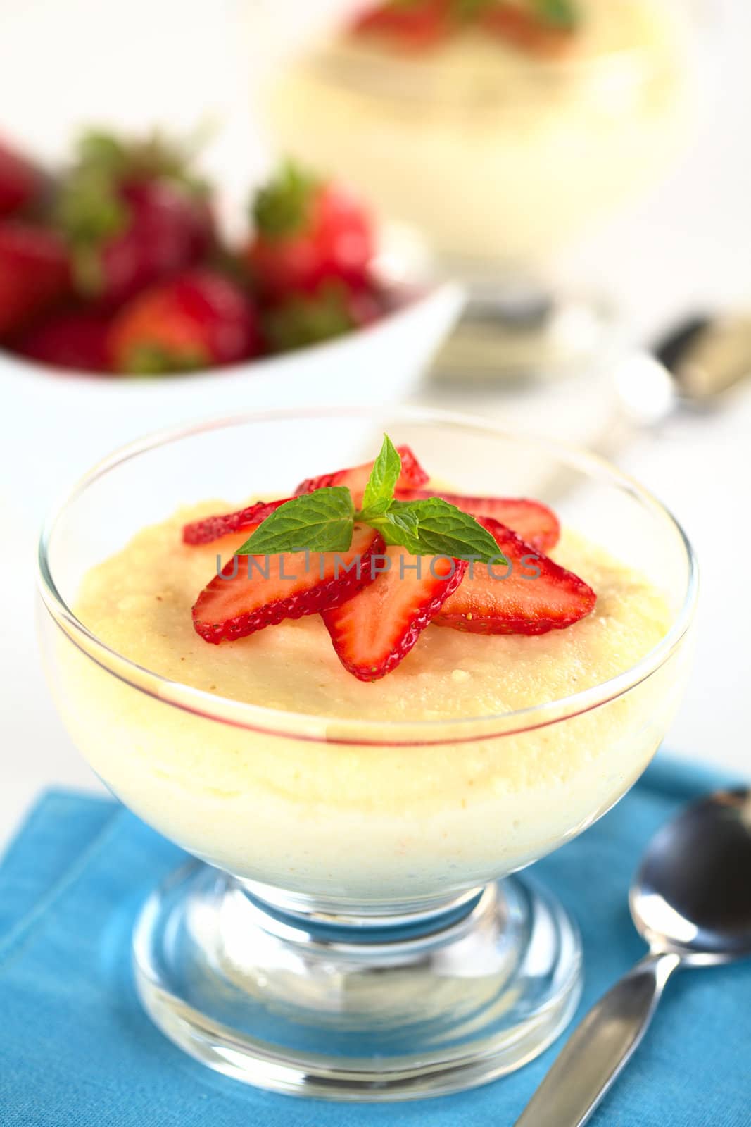 Semolina pudding with strawberry slices and mint (Selective Focus, Focus on the mint leaf)