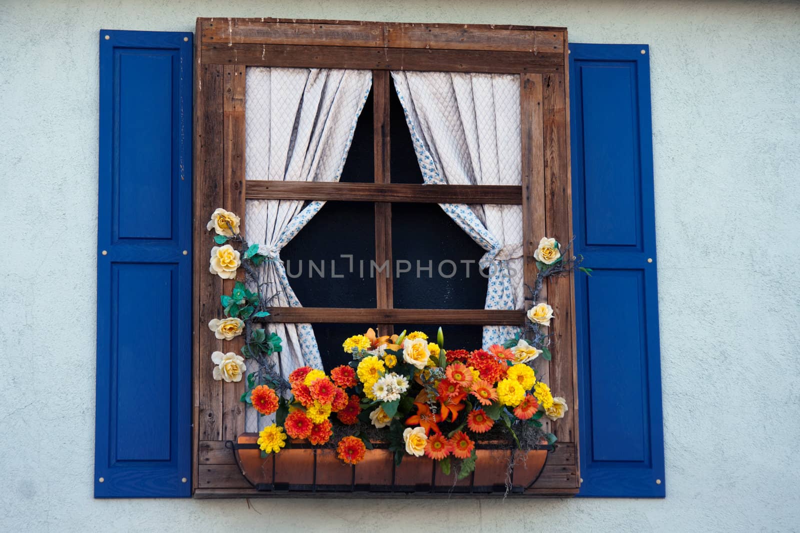 Country style window with flowers,planter, shutters and curtains