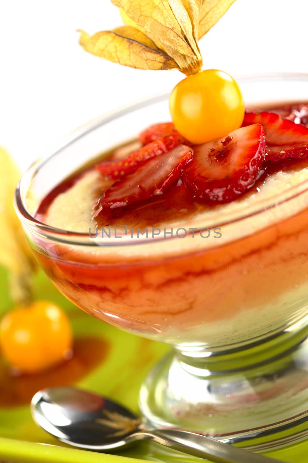 Semolina pudding with strawberry, strawberry sauce and physalis (Selective Focus, Focus on the front of the left strawberry slice)