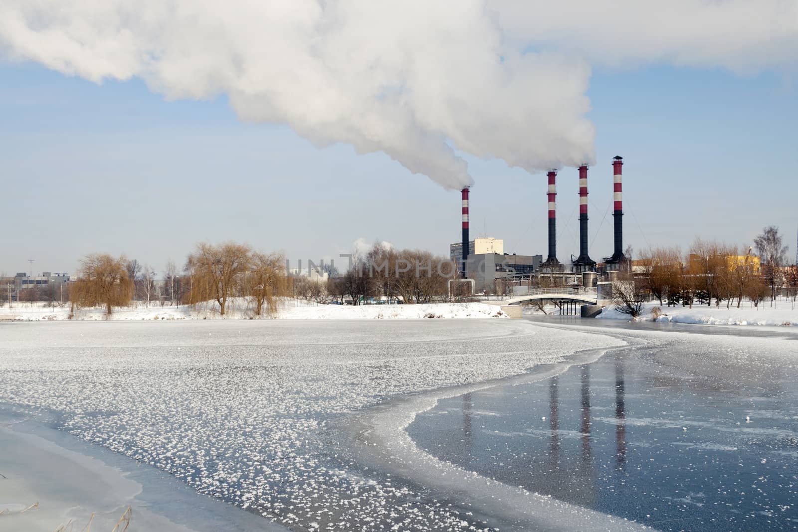 industrial cityscape with frozen river and power plant chimneys on backward in Minsk, Belarus