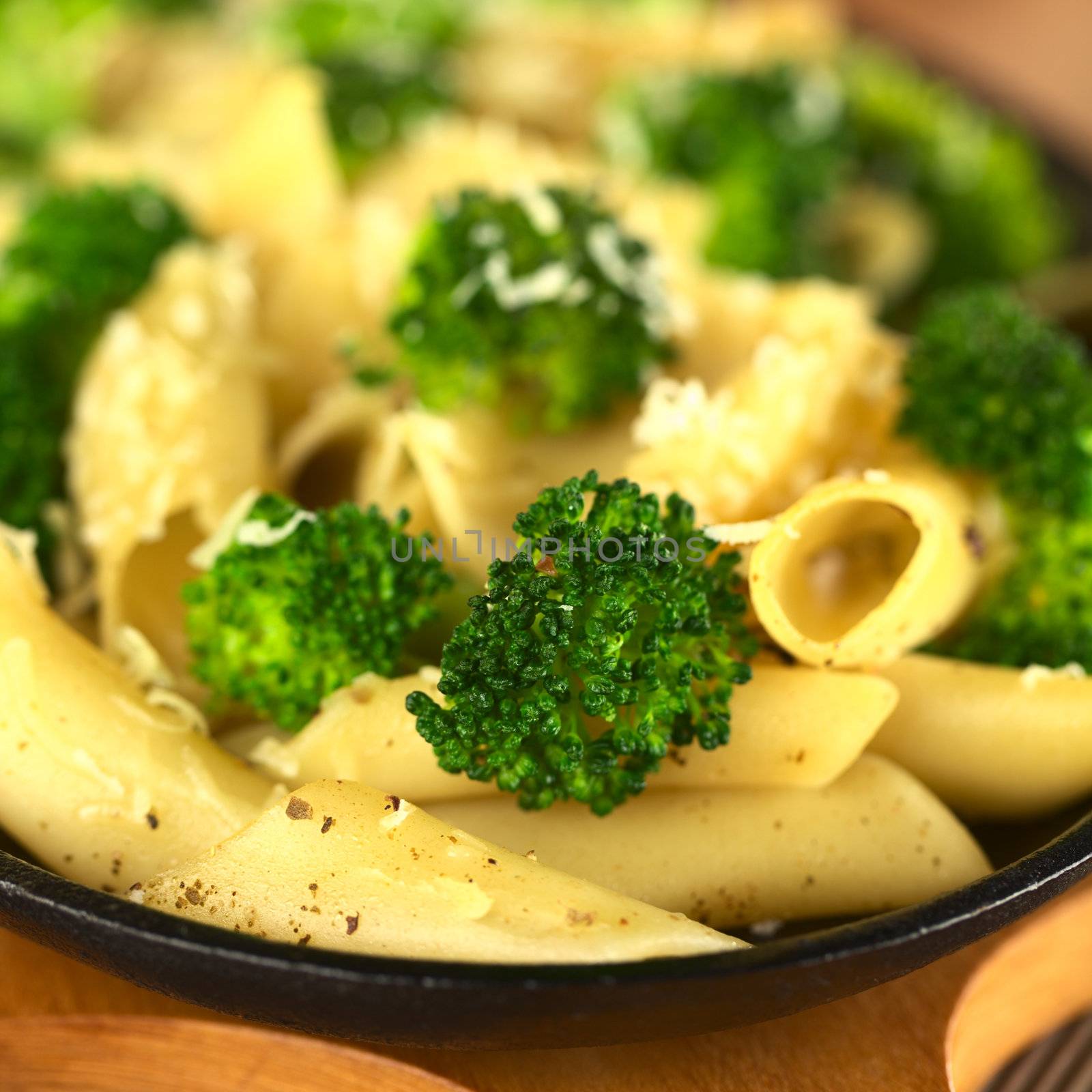 Broccoli and pasta baked with grated cheese and ground pepper (Selective Focus, Focus on the broccoli floret in the front)