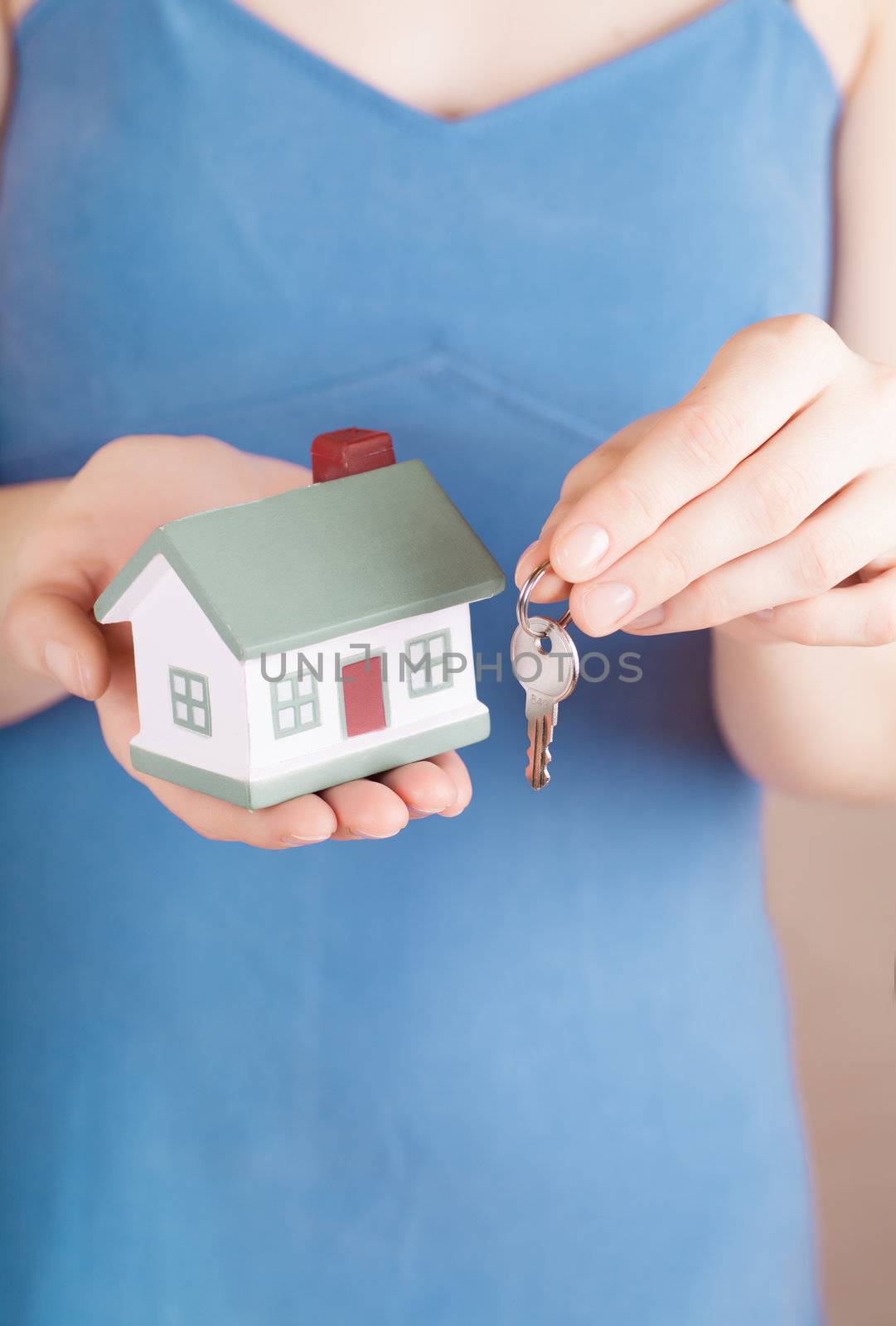 Little house toy and a key in woman hands