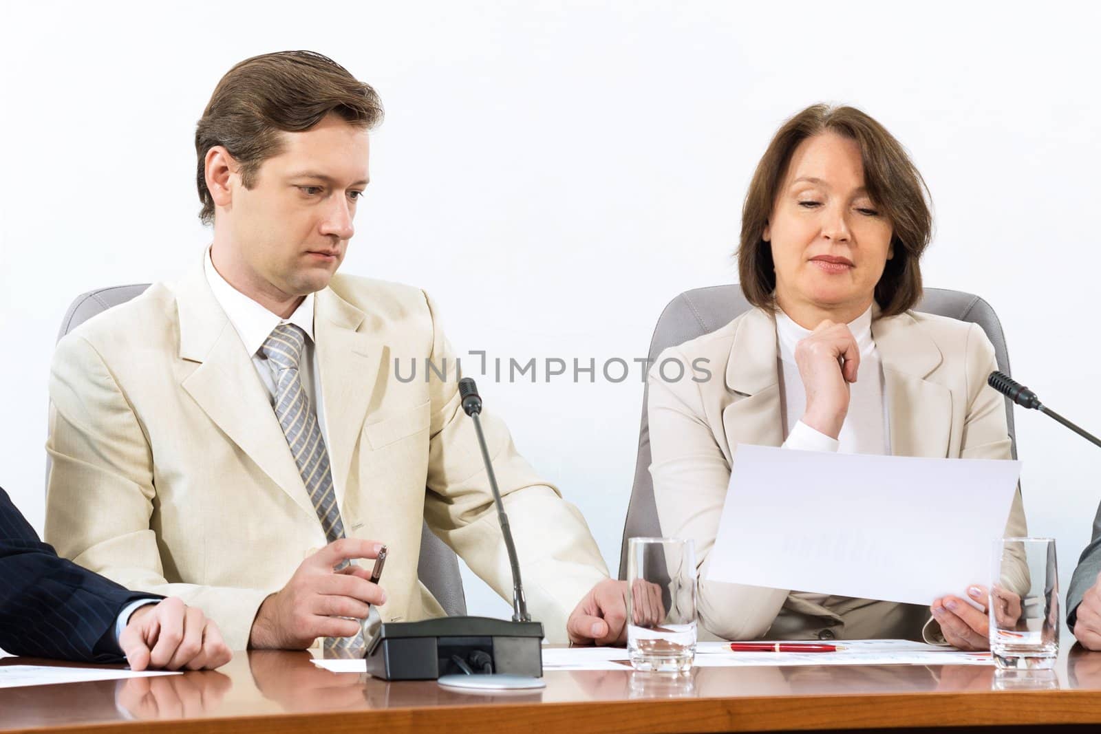 Senior business woman working with documents at the conference, on the table microphone stand