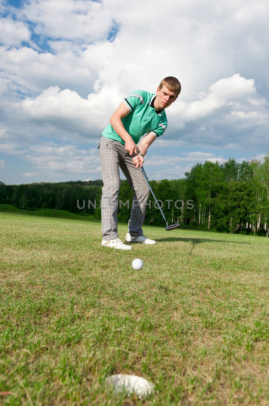 Golf green hole course man putting ball inside short putt