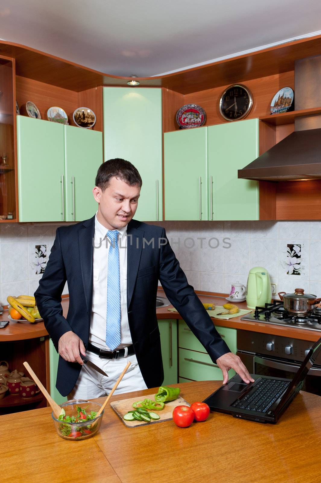 Young man preparing salad at the kitchen