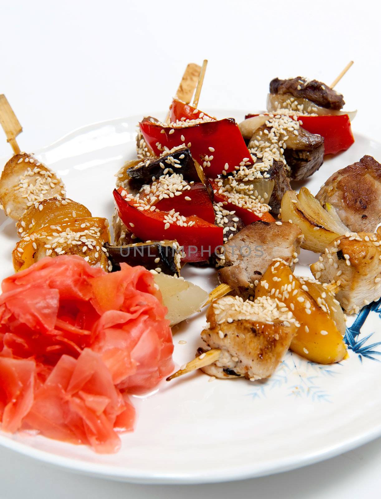 Meat skewers on a plate isolated on white background