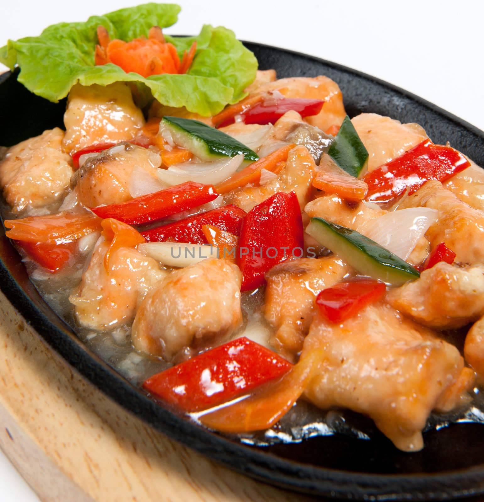 Roasted salmon with vegetables on frying pan isolated on white background