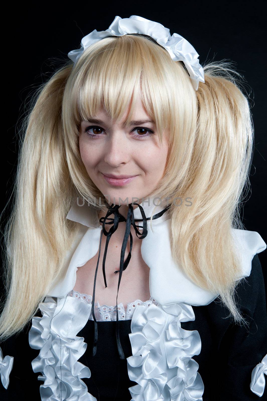 Portrait of young girl in anime lolita suit on black background