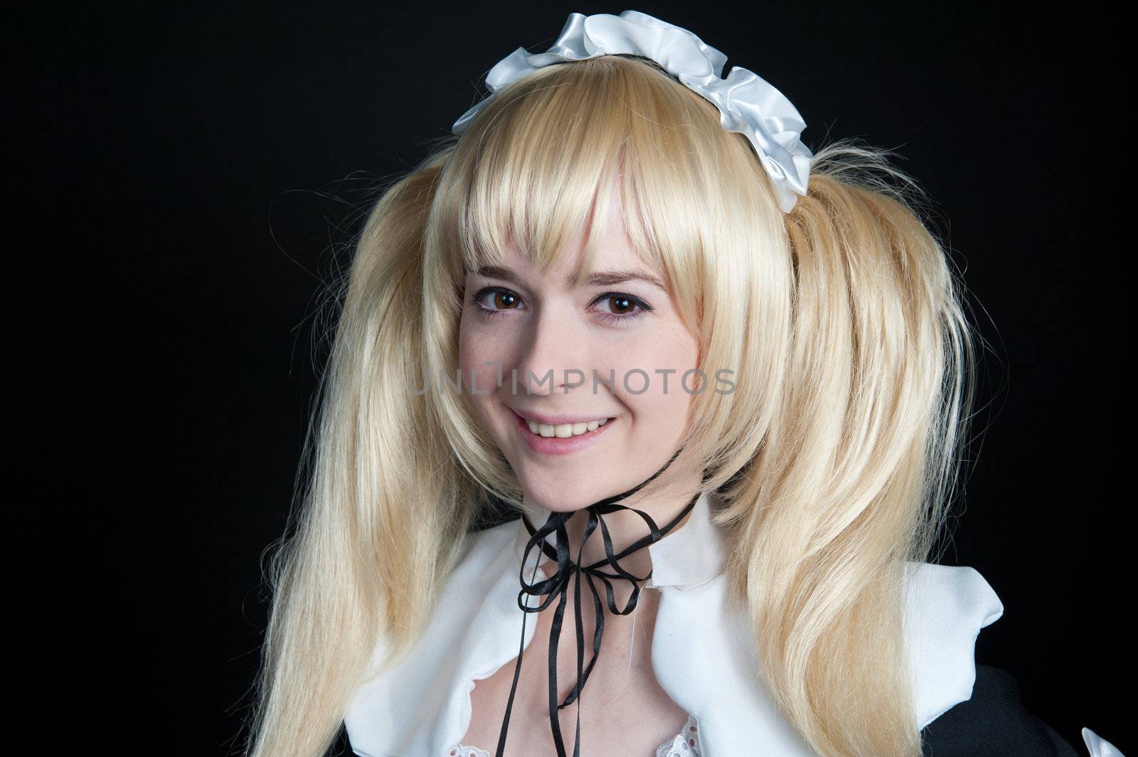 Portrait of young girl in anime lolita suit on black background