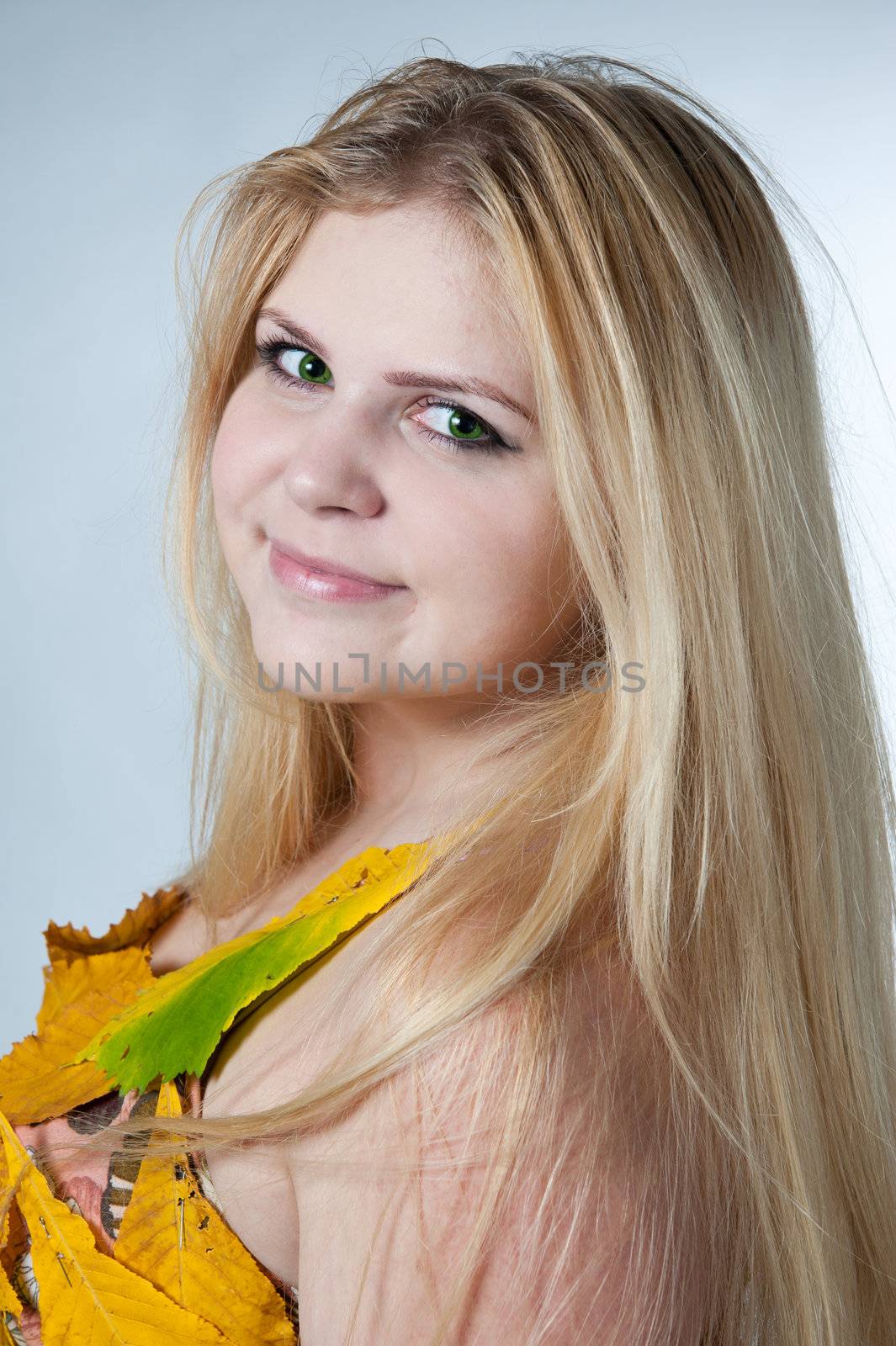 portrait girl in dress decorated with autumn leaves on white background