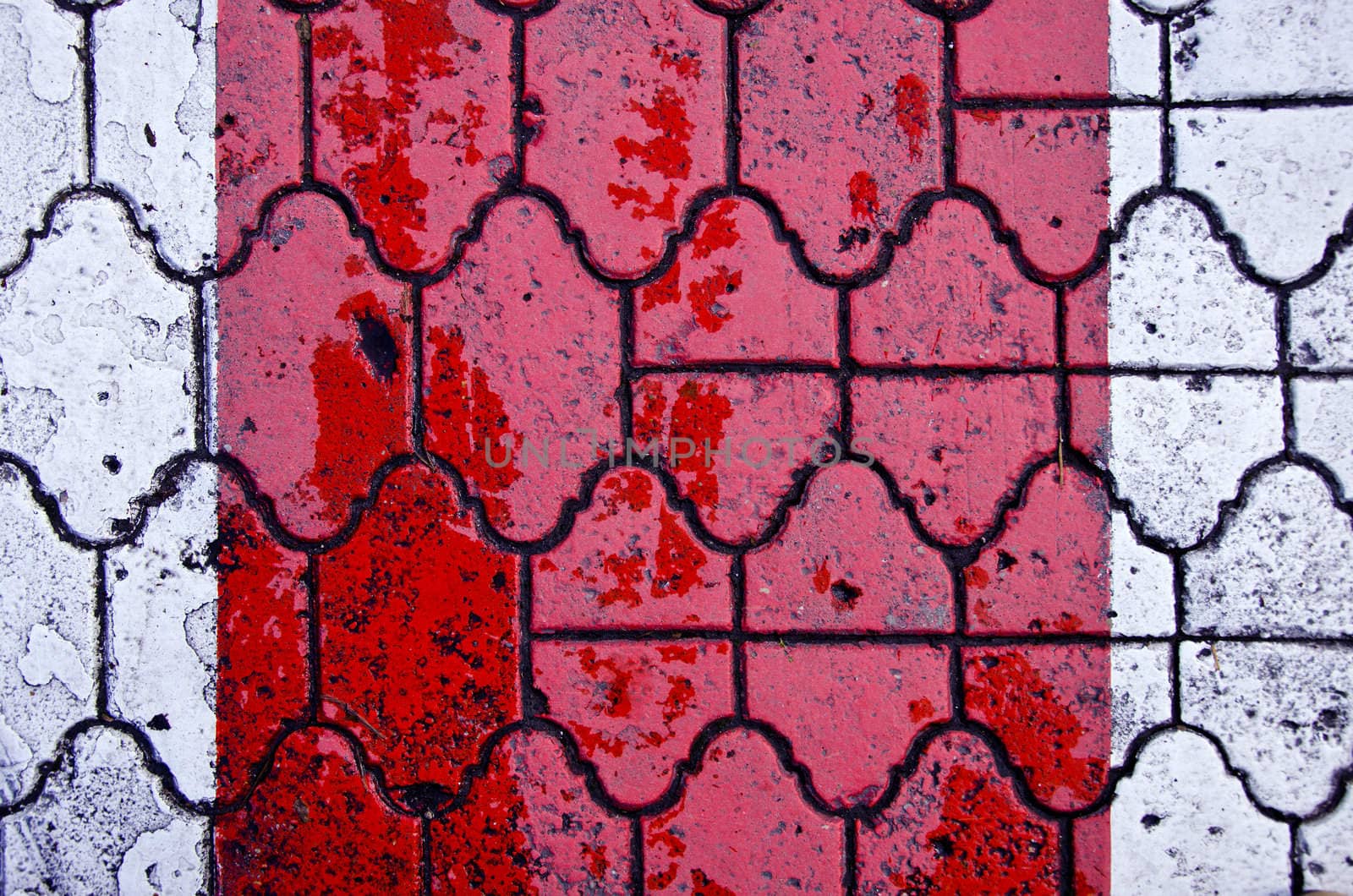 Background of red color crosswalk on road paved by decorative tiles.