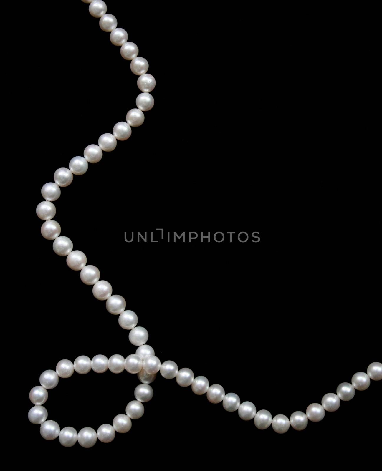 White pearls on the black velvet  background