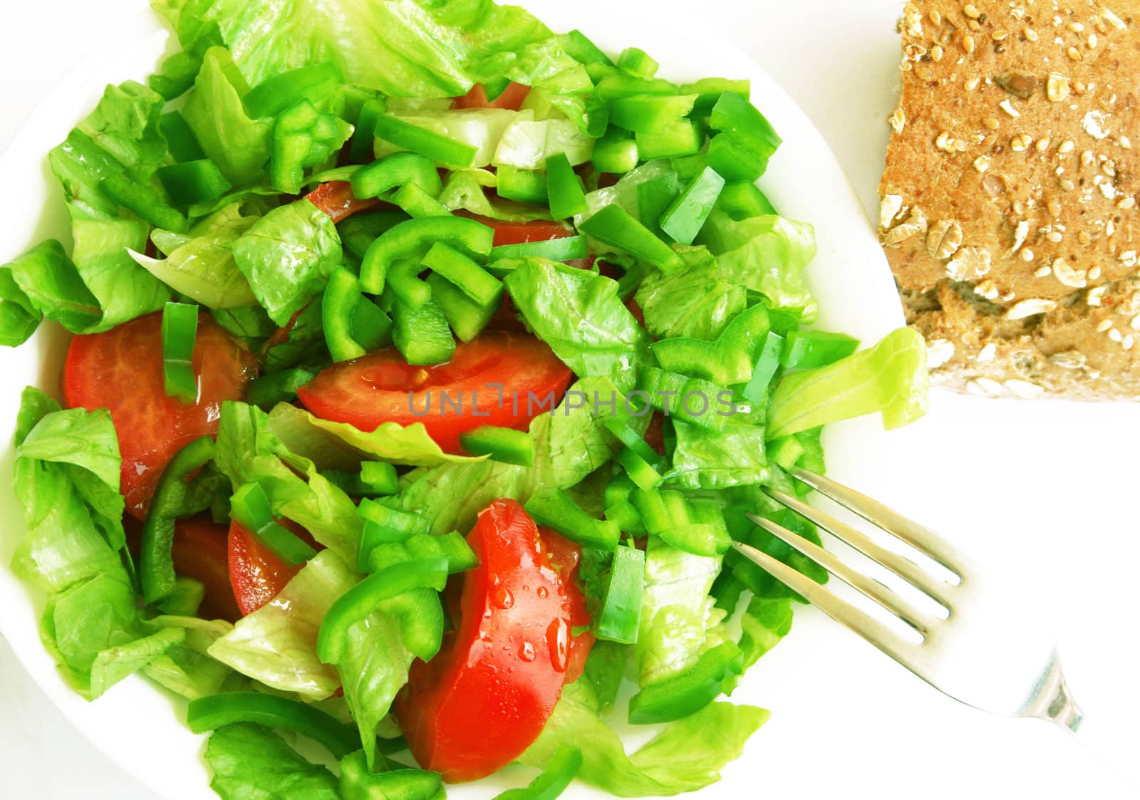 Healthy vegetarian Salad and bread on the white plate over white 