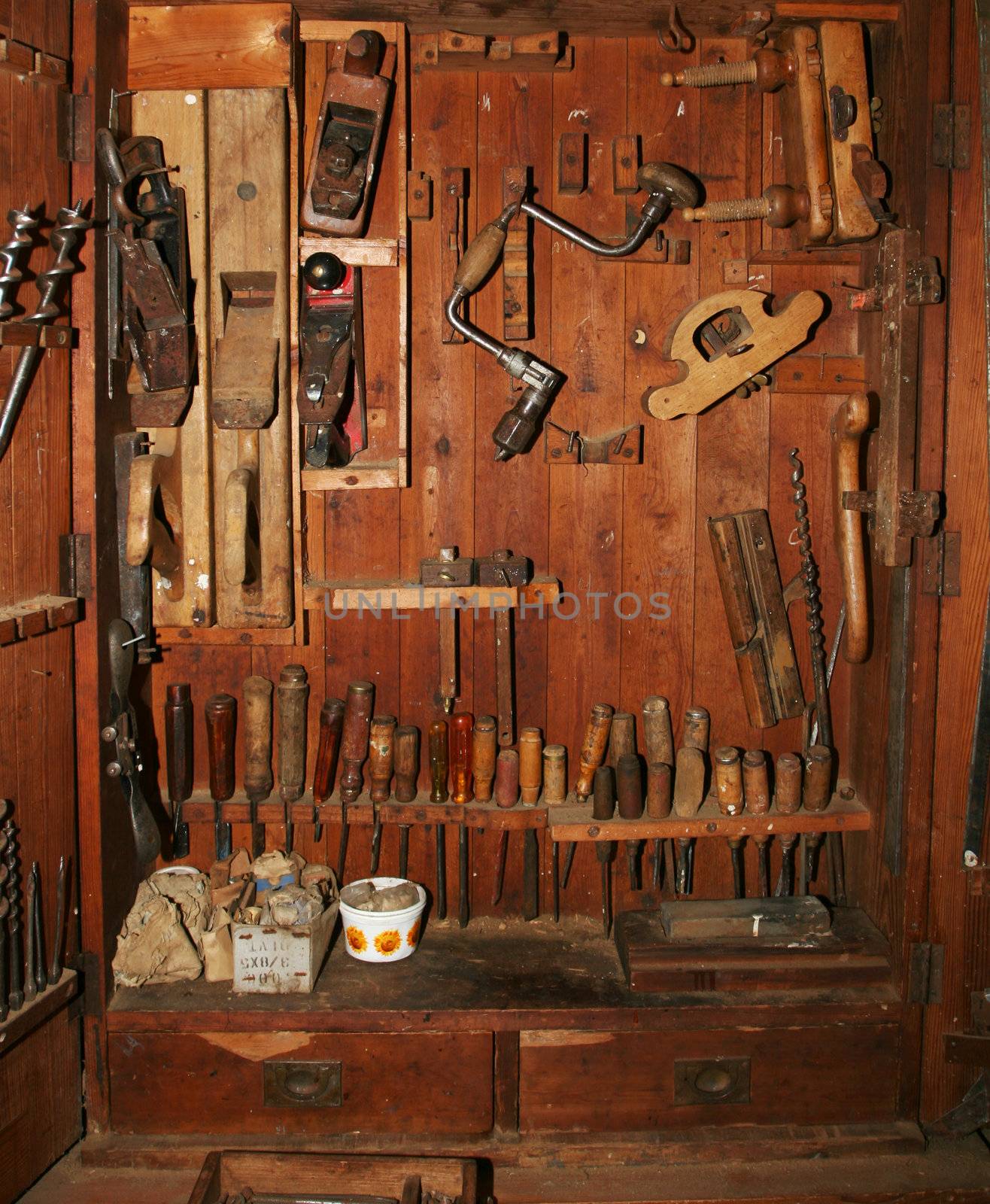 Very old and worn woodworking tools in worn down cabinet