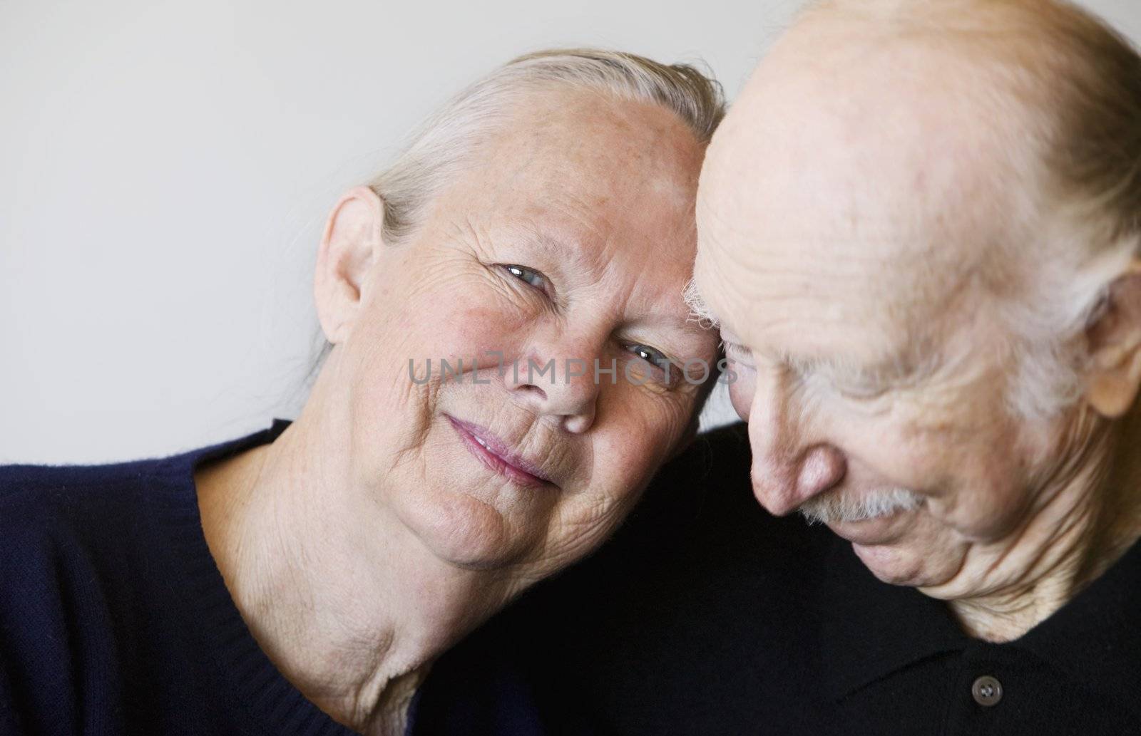 Close-up of senior couple embracing focuses on smiling woman