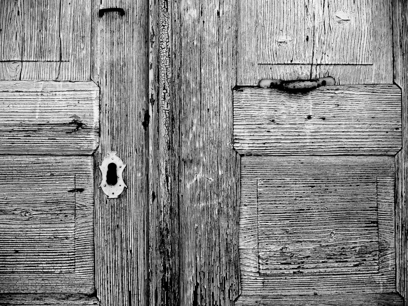 detail of an old weathered wooden door, keyhole, black white