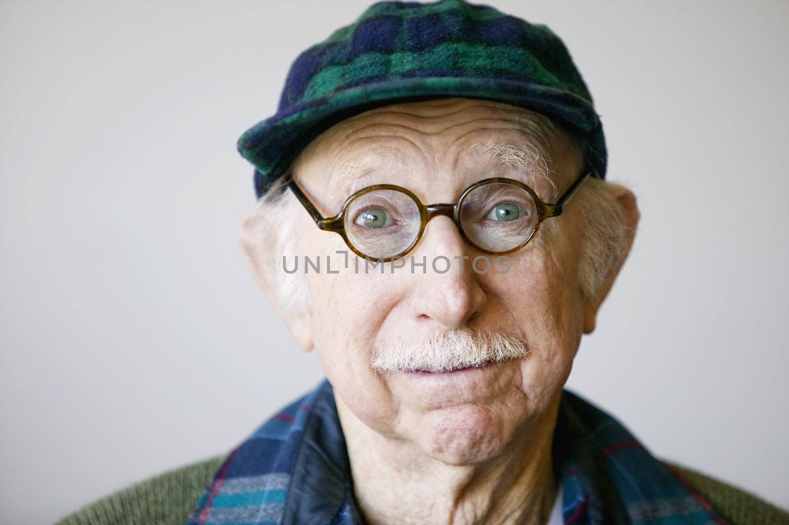 Portrait of a senior citizen wearing glasses and a sweater. 