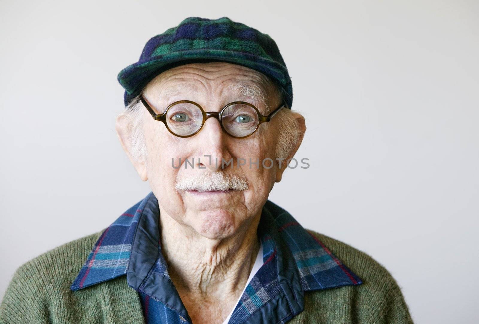Portrait of a senior citizen wearing glasses and a sweater.