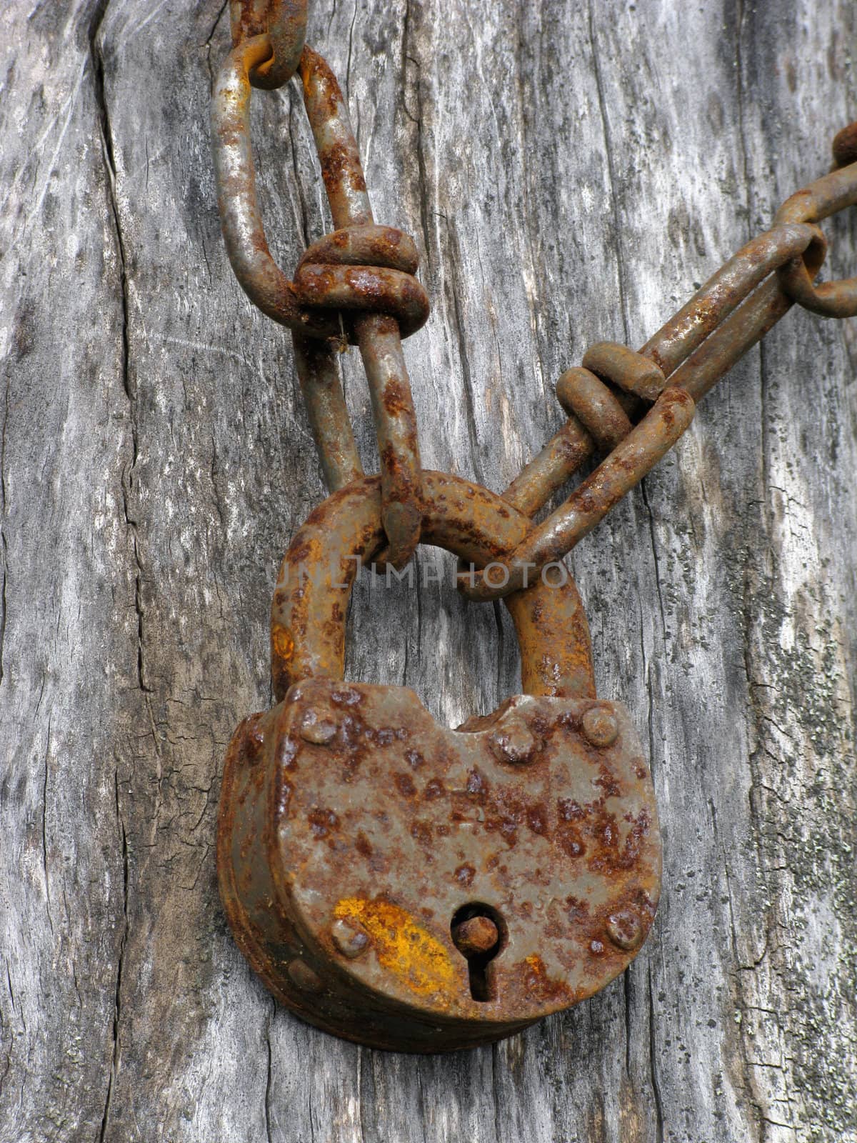 Closeup of an old padlock and rusty chain