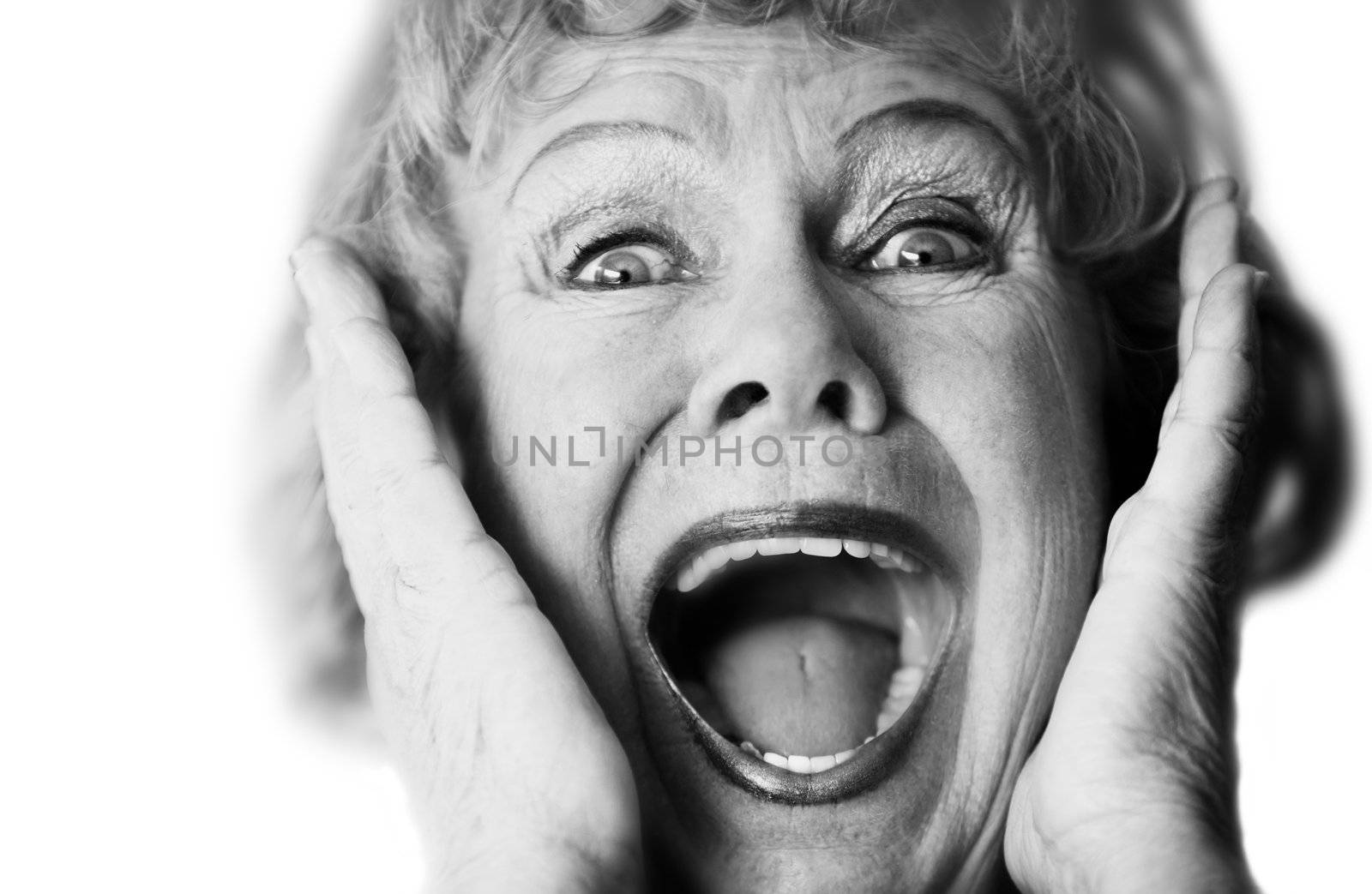Close-up of a senior woman with her mouth open screaming.