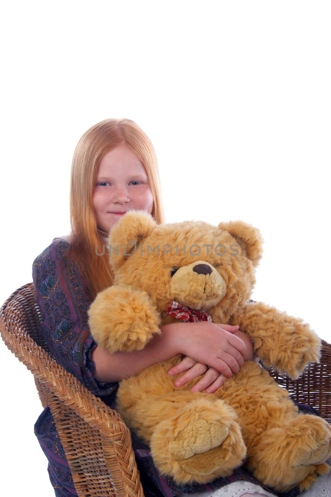 Redhead girl and her big toy baer are sitting in the armchair